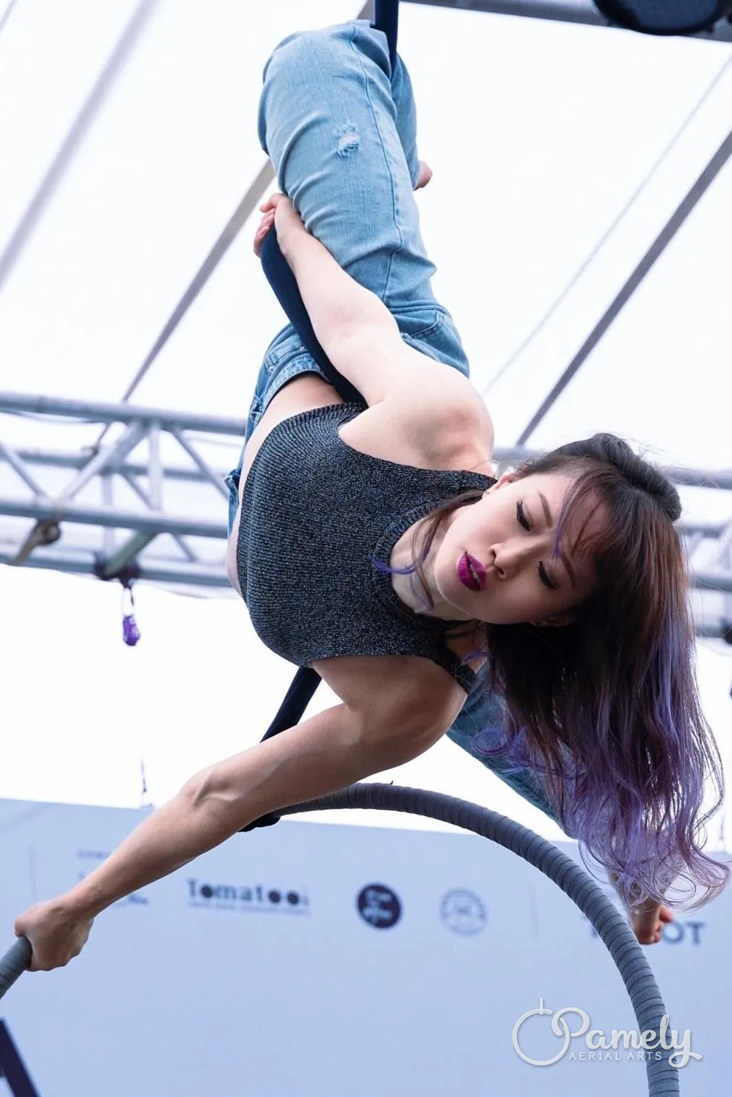 Pamely hanging from the hoop at an event