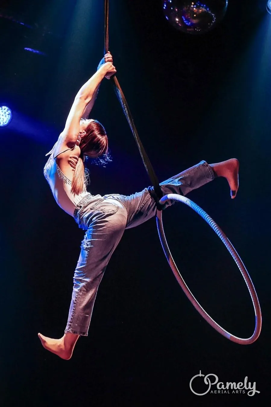 Pamely in an arabesque on the hoop on stage