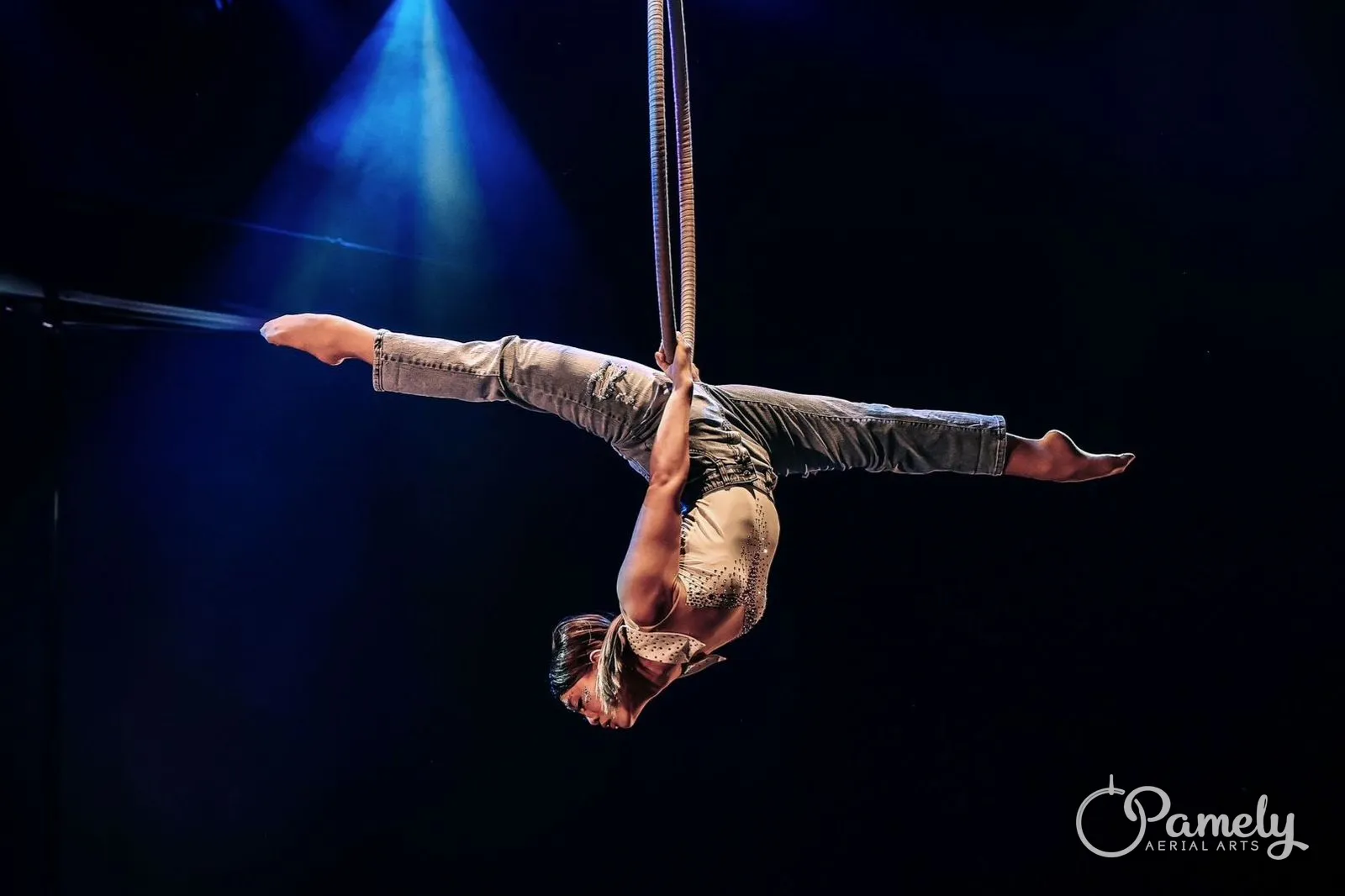 Pamely stretched across the hoop under stage lights