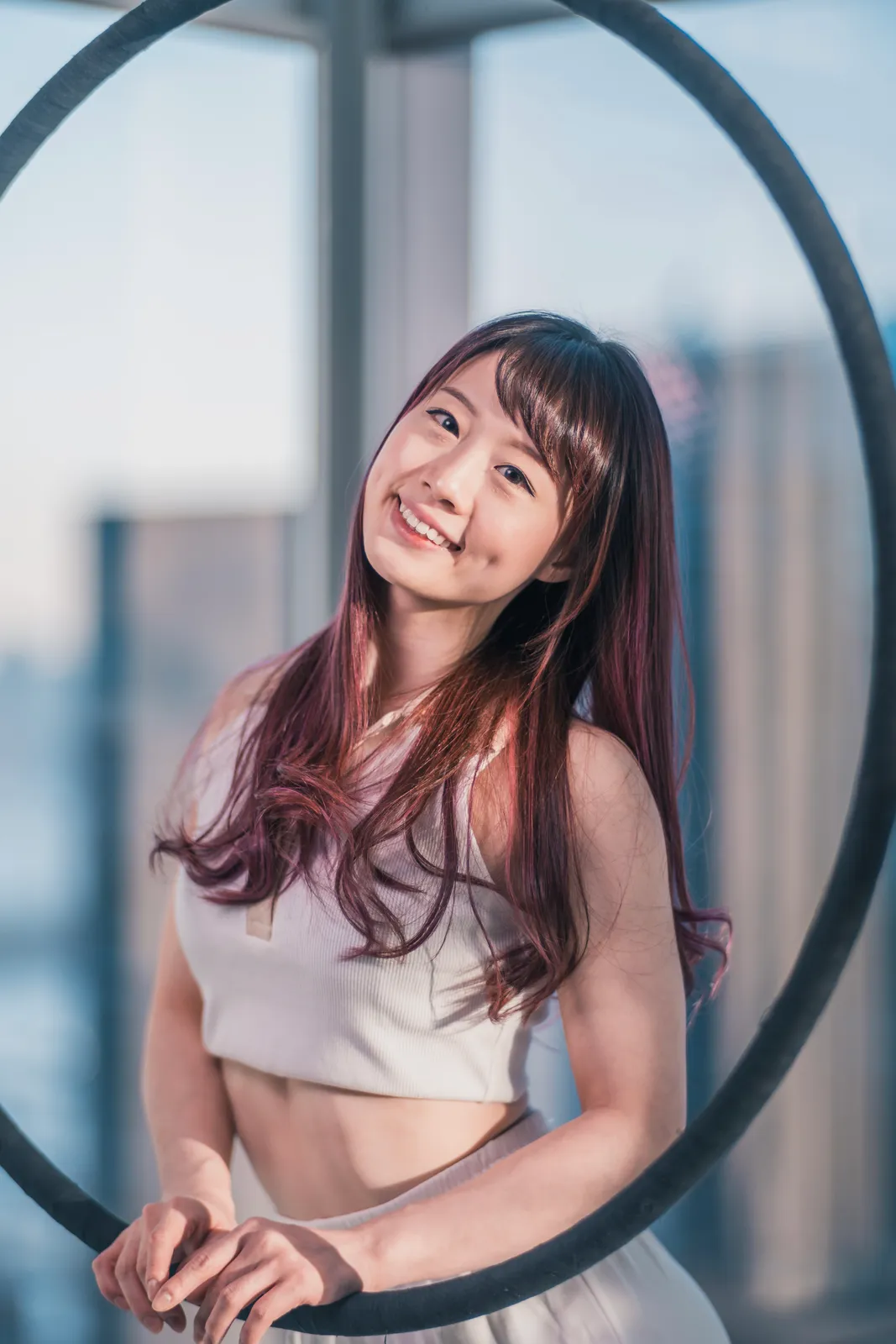 Portrait of Pamely smiling beside an aerial hoop